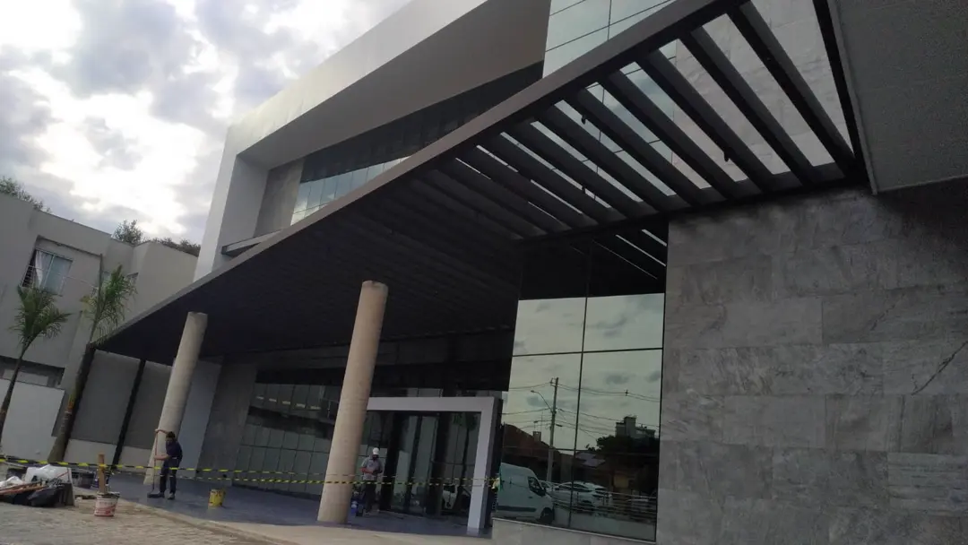 Entrada do Sicredi com pergolado metálico e fachada em vidro